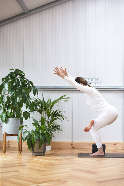 atleta di mezza età che pratica posture yoga complicate mantenendo l'equilibrio. - Foto, immagini