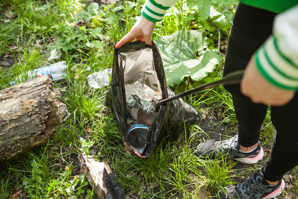 Neznámá žena sbírá odpadky v lese po pikniku - Fotografie, Obrázek