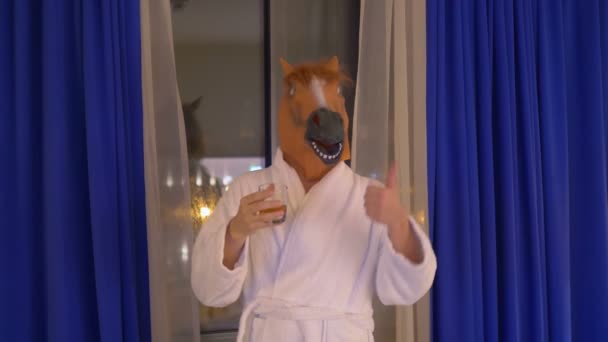 Uomo in maschera di cavallo rilassante e bere whisky dopo il lavoro in 4k slow motion 60fps - Filmati, video
