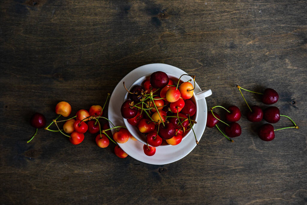 Summer background with ripe sweet cherries in wooden  bowls - Фото, изображение