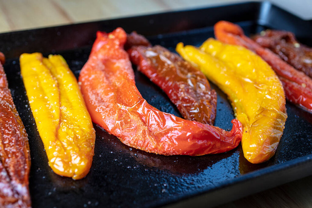 Alleen geroosterde oranje, rode en paarse Poivron pepers gekookt in de oven in een gietijzeren grillpan - Foto, afbeelding