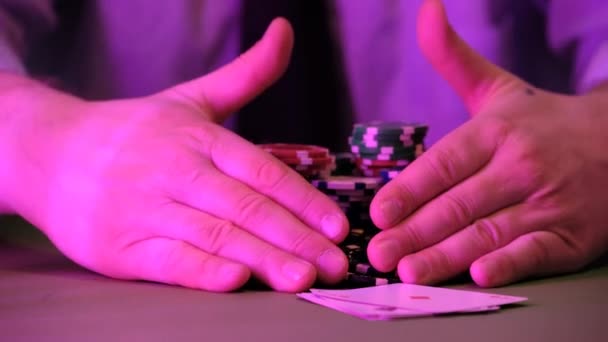Ten muž hraje v kasinu. Nad stolem jsou vidět pouze čipy a ruce. Pozadí je velmi rozmazané. - Záběry, video