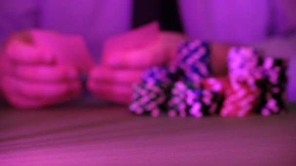 The man plays in the casino. Only chips and hands are visible above the table. The background is very blurry. - Footage, Video