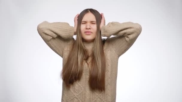 Nuori tyttö tunne ärsyttää kovaa melua ja kärsii päänsärky sulkemalla korvat kädet - Materiaali, video