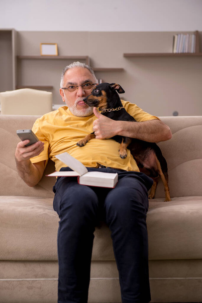 Alter Mann mit kleinem Hund zu Hause - Foto, Bild