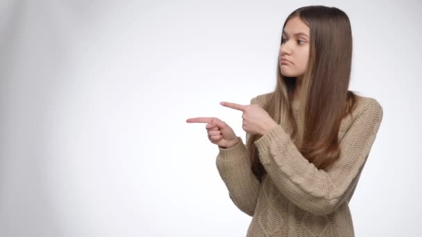 Rapariga apontando do seu lado e mostrando produto invisível. Coloque seu produto ou objeto. Modelo de publicidade - Filmagem, Vídeo
