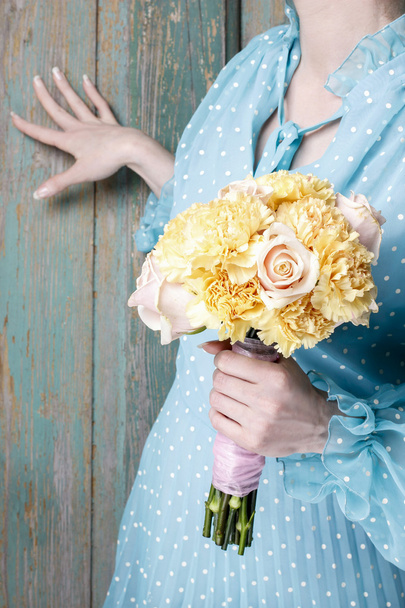 Woman holding bouquet of yellow carnation and pink roses - Fotoğraf, Görsel