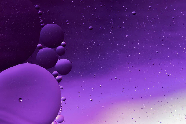 burbujas líquidas aceitosas translúcidas en la superficie del agua, gotas de aceite en la superficie del agua - Foto, Imagen