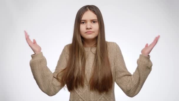 Zmatená nebo zmatená dívka pochybuje o správné volbě nad bílým studiem pozadí - Záběry, video