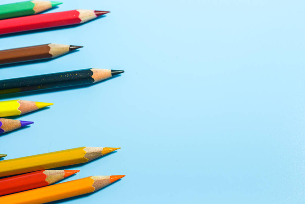 row of colorful pencils on blue background - Foto, imagen