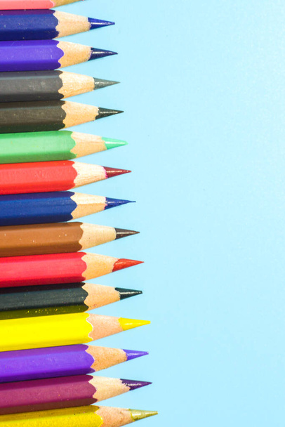 fila de lápices de colores sobre fondo azul - Foto, imagen