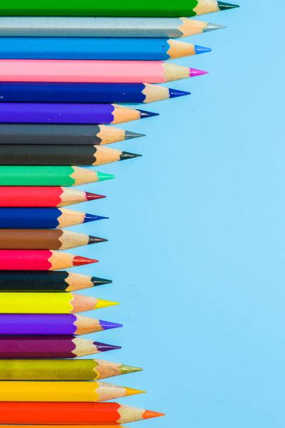 fila de lápices de colores sobre fondo azul - Foto, imagen