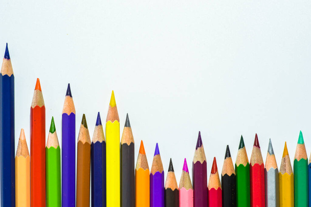 row of colorful pencils on blue background - Photo, Image