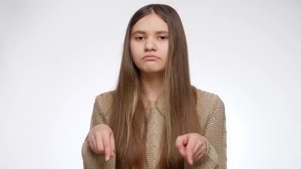 Retrato de adolescente anunciando y señalando con el dedo en su lado sobre fondo blanco. Coloca tu producto u objeto. Plantilla publicitaria - Metraje, vídeo