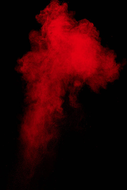 Nube de explosión de polvo rojo sobre fondo negro. - Foto, imagen