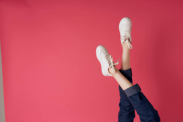 женские ноги вверх ногами обрезанный вид розовый фон моды - Фото, изображение