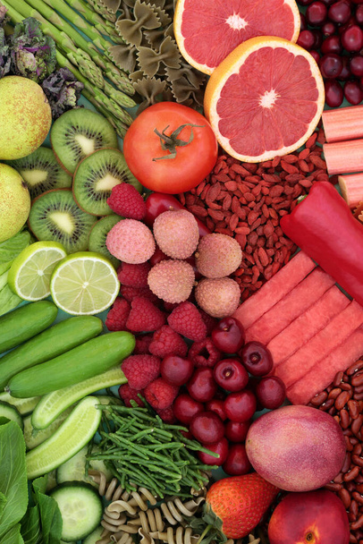 Grünes und rotes ballaststoffreiches Essen für eine gute Verdauung mit Obst, Gemüse und Nudeln. Lebensmittel auch reich an Antioxidantien, Mineralstoffen, Lycopin, intelligenten Kohlenhydraten und Vitaminen. Gesundheitskonzept.  - Foto, Bild