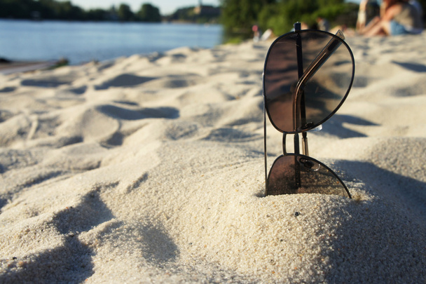 Gafas de sol femeninas en la playa, sol y arena
 - Foto, Imagen