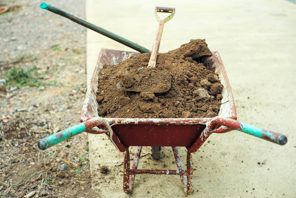 Selective focus on pile of soil on the steel shovels in the wheelbarrow - Foto, immagini