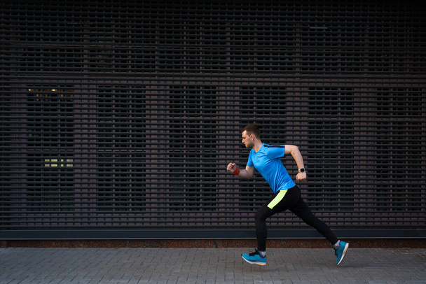 Homem atlético correndo na rua urbana contra fundo cinza - Foto, Imagem