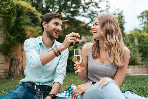 イチゴとスパークリングワインを飲むカップル - 写真・画像