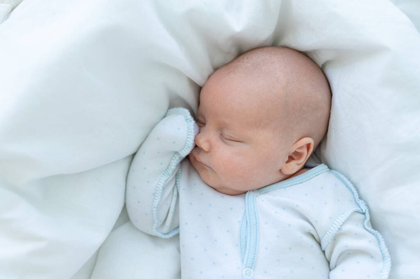 niño recién nacido duerme siete días en una cuna en casa en una cama de algodón, primer plano - Foto, Imagen