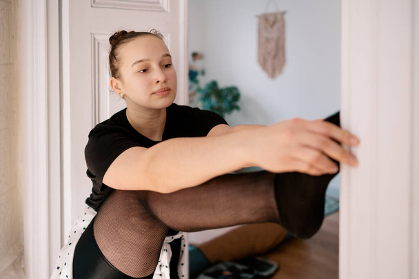 WOMAN stretching leg on door getting ready to extend in a string - Photo, Image