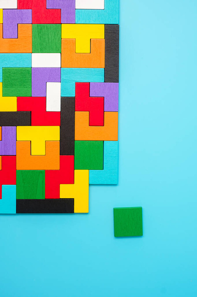 barevné dřevěné puzzle kousky na modrém pozadí, geometrický tvar bloku. Koncepty logického myšlení, hlavolam, řešení, racionální, strategie, světová logika den a vzdělávání - Fotografie, Obrázek