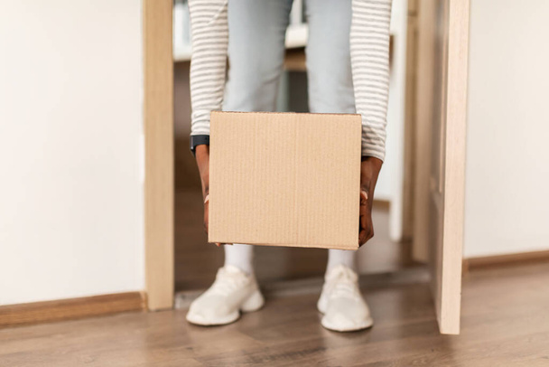 Black Lady Taking Cardboard Parcel Box From Floor Entering House - Fotoğraf, Görsel