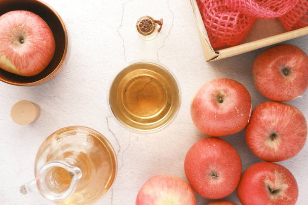 テーブルの上に新鮮な赤いリンゴとガラス瓶のリンゴ酢  - 写真・画像