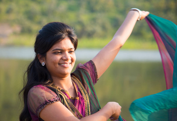 Genç mutlu Hintli kız pembe eşarbıyla dışarıda oynuyor.. - Fotoğraf, Görsel