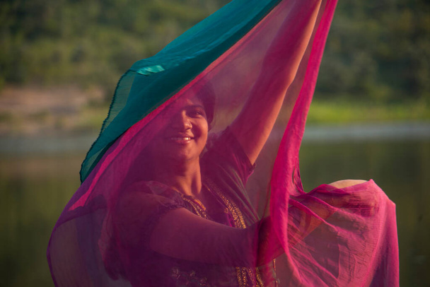 Genç mutlu Hintli kız pembe eşarbıyla dışarıda oynuyor.. - Fotoğraf, Görsel