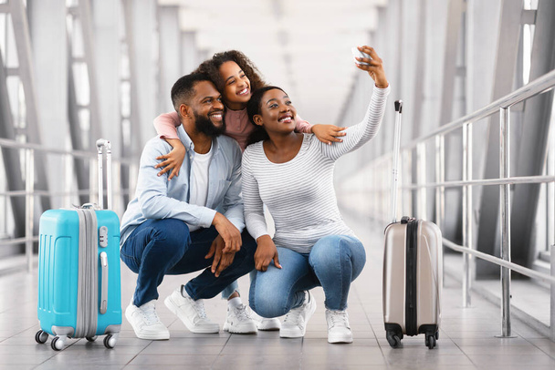 Famiglia nera di tre persone che viaggiano, facendo selfie in aeroporto - Foto, immagini