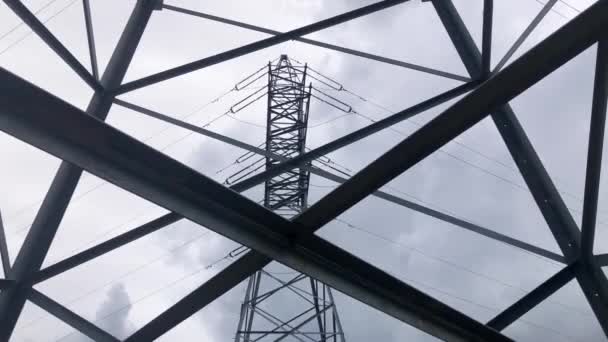 Inspection of a metal high-voltage pole from bottom to top against a blue sky. Power networks for transmission and transportation of electricity - Footage, Video