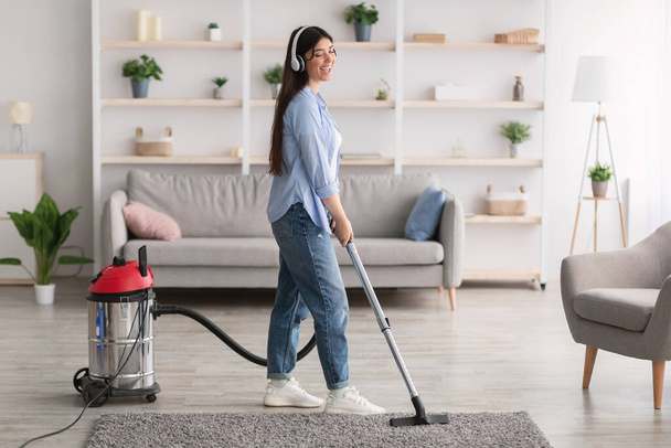 Woman cleaning house, singing and using hoover - Foto, imagen