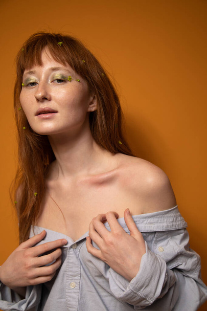 Female with nude make-up and green eyeshadows touching her gorgeous shoulders - 写真・画像