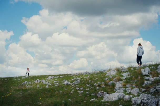 People walk on a green meadow in Durmitor park, Montenegro - Photo, Image