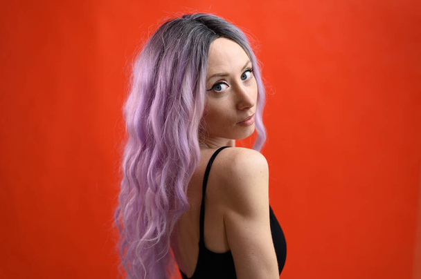 Photo of a caucasian girl with multi-colored hair. Isolated portrait on red background - Valokuva, kuva
