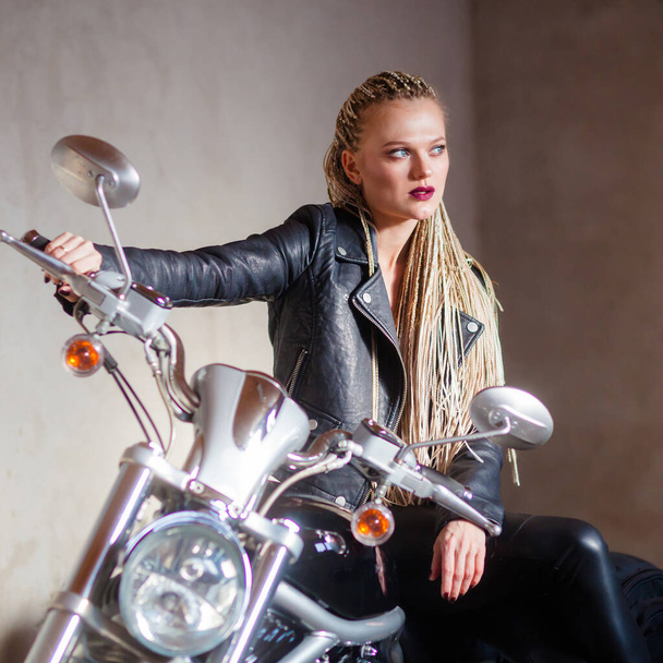 chica motorista con rastas posando en una motocicleta - Foto, imagen