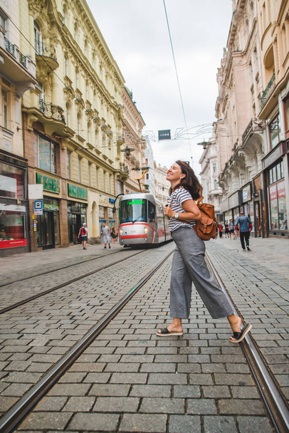 vrouw wandelen door brno oude stad straat moderne openbare tram op achtergrond reizen concept - Foto, afbeelding