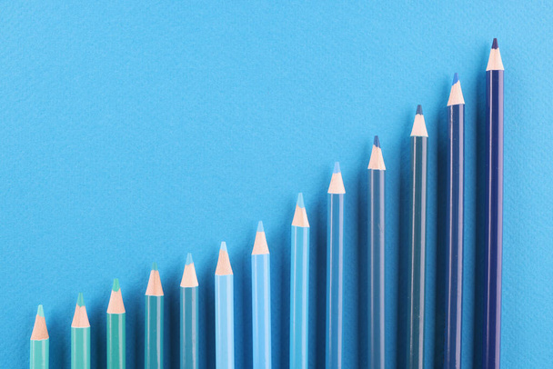 Farklı tonlarda kalemler mavi arkaplanda yatar - Fotoğraf, Görsel