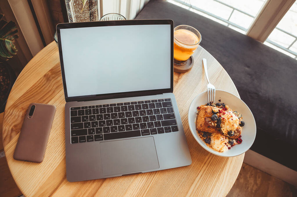 laptop in cafe op tafel met wit scherm in cafe kopieerruimte - Foto, afbeelding