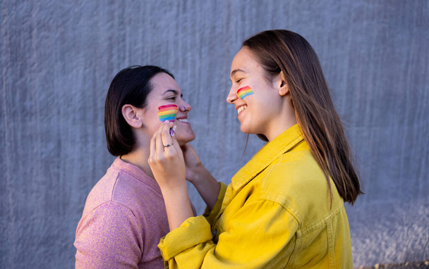 lesbian girls having fun painting themselves and with the lgtb flag on pride daylgtb concept - Φωτογραφία, εικόνα