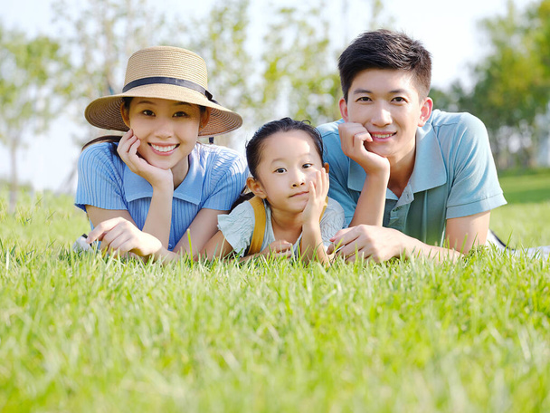 Happy family of three on the grass - Zdjęcie, obraz