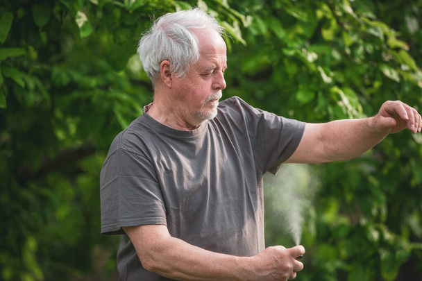 Старший человек распыления или использования репелленты против вида насекомых, комаров и клещей в лесу, защитный спрей, концепция здравоохранения - Фото, изображение