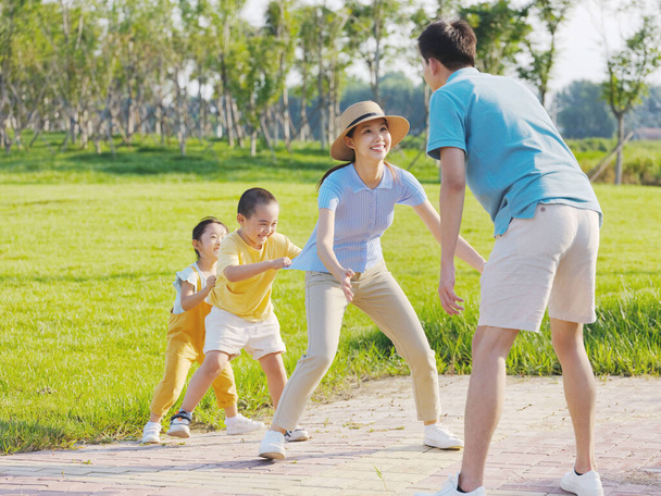 Happy family of four playing games in the park - Foto, Imagen