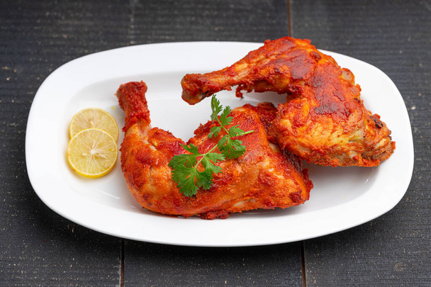 Жареная куриная нога или барабанная палочка жаркое, пряный индийский цыпленок жаркое с черным фоном, избирательный фокус - Фото, изображение