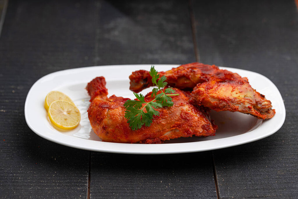 Fried chicken leg or drum stick fry, pikantny indyjski kurczak smażony na czarnym tle, selektywne skupienie - Zdjęcie, obraz