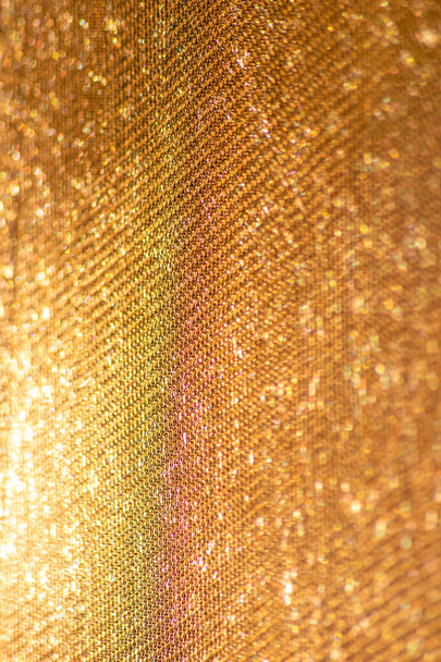 La estructura de malla amarilla en primer plano con luz de fondo en la mañana brillante muestra un patrón abstracto de material sin costuras texturizado en luz dorada como elemento gráfico para el fondo de pantalla y la tela macro - Foto, imagen