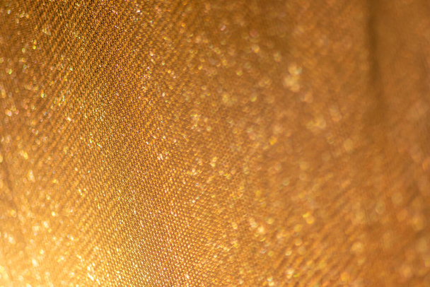 La estructura de malla amarilla en primer plano con luz de fondo en la mañana brillante muestra un patrón abstracto de material sin costuras texturizado en luz dorada como elemento gráfico para el fondo de pantalla y la tela macro - Foto, imagen